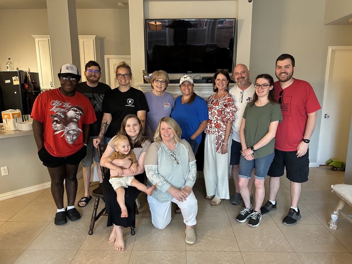 A Home Group gathered in a living room for a group photo, adults and a toddler