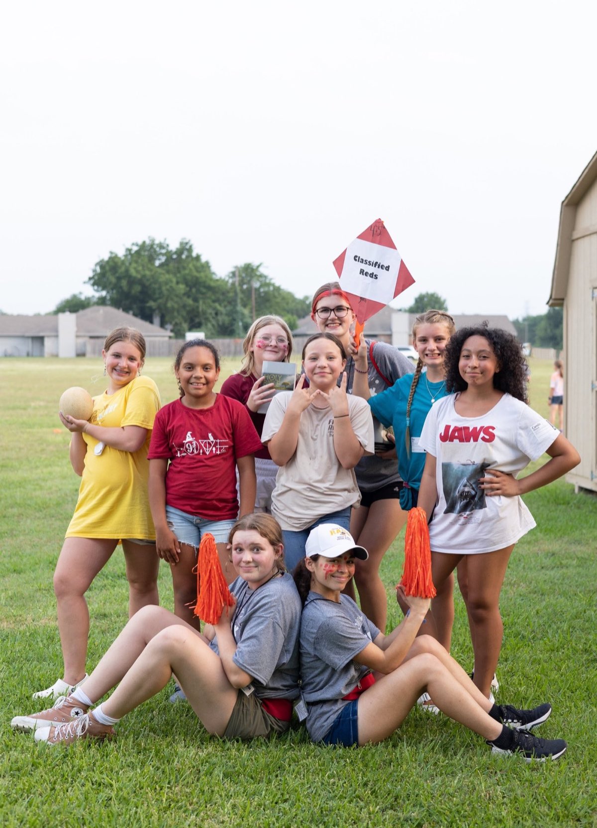 Students posing with pom-poms on the lawn at VBS Rec Week